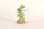 Preview: bunte Metallfigur Hase grün Frühlingsdeko auf Holzsockel bestellen