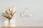 Preview: Deko-Schild Carpe Diem aus Holz, beige mit schwarzer Schrift, aufgehängt an einer weißen Wand als inspirierende Wohnzimmer-Dekoration