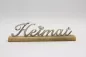 Preview: Freistehender Schriftzug Heimat aus silbernem Metall auf Regal