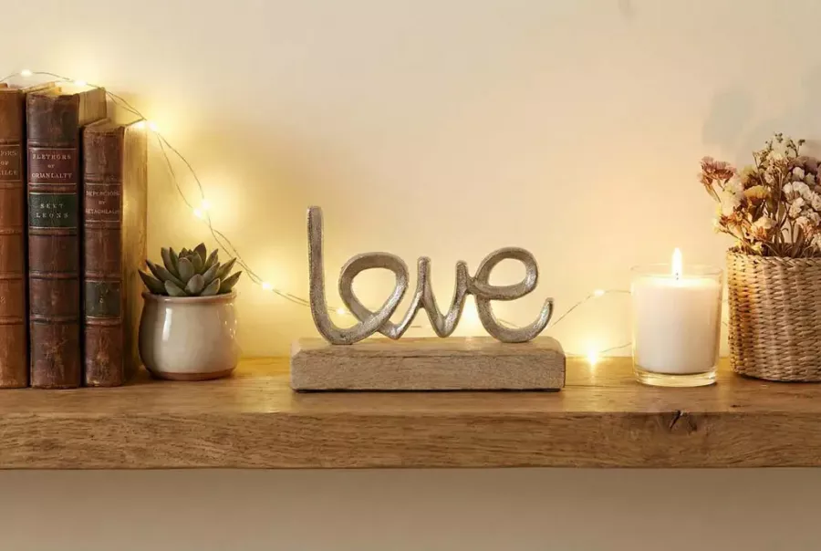 Schriftzug „Love“ aus Metall auf Holz – romantische Wohnraumdekoration