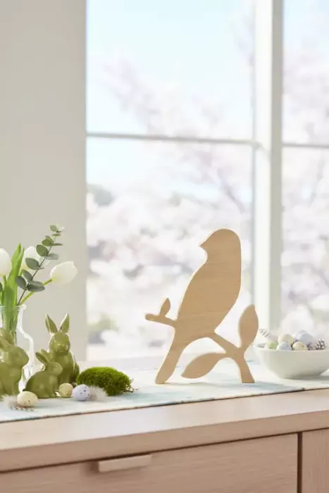 Dekorativer Vogel auf Ast mit zarten Blättern aus Buche – perfekte Tischdeko für Frühling & Sommer.