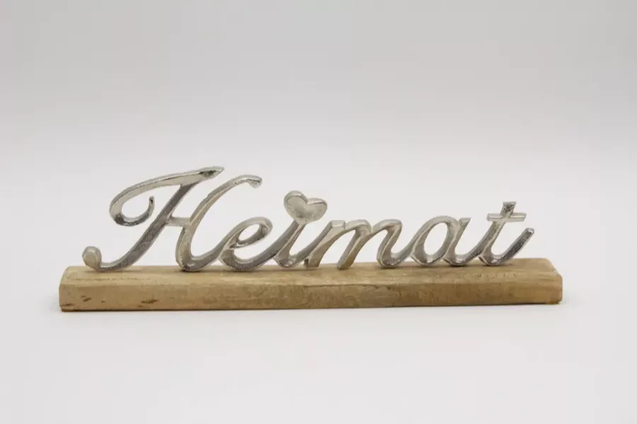 Preview: Freistehender Schriftzug Heimat aus silbernem Metall auf Regal