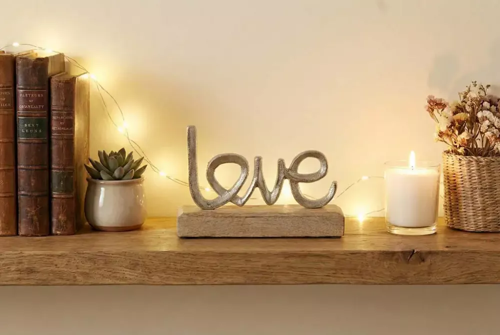Schriftzug „Love“ aus Metall auf Holz – romantische Wohnraumdekoration