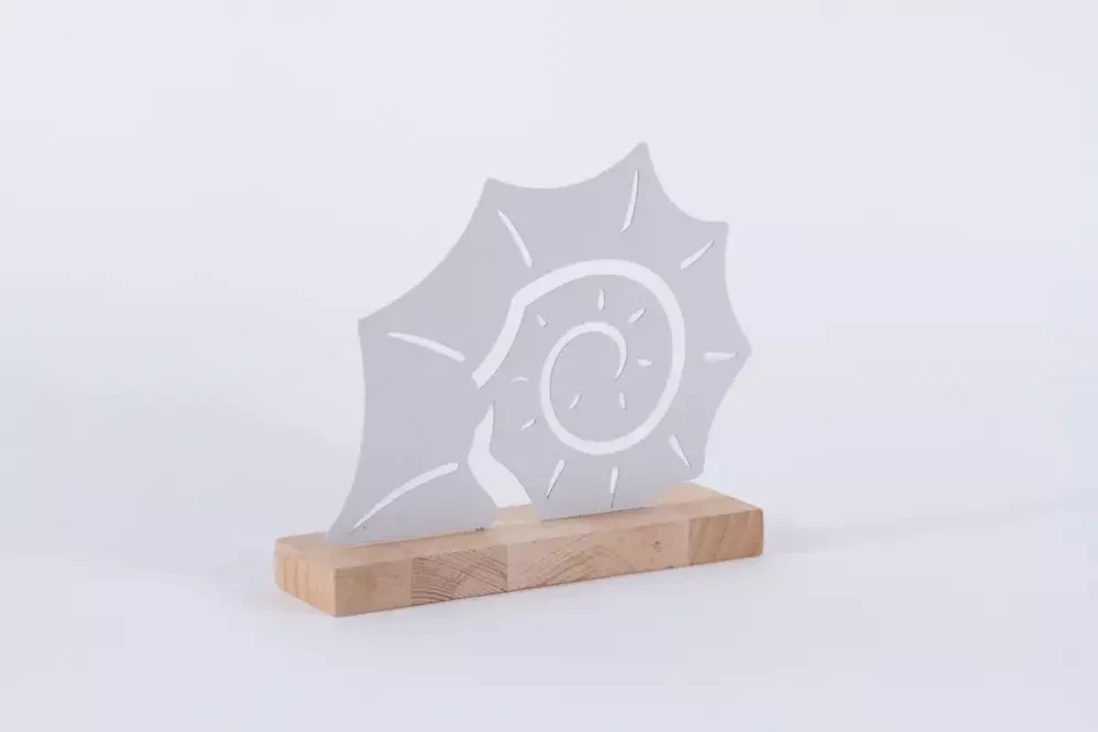 Muschel aus Metall auf Holz maritim