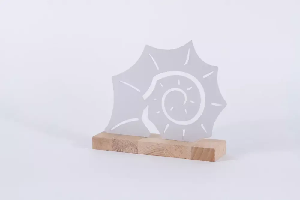 Muschel aus Metall auf Holz maritim