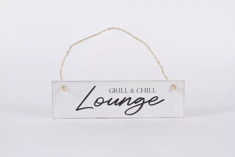 Deko-Schild Grill & Chill Lounge aus Holz, braun mit weißer Schrift, aufgehängt an einer rustikalen Holzwand im Gartenbereich als gemütliche Grillplatz-Dekoration