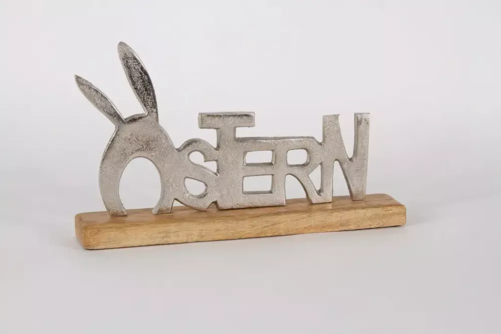 Schriftzug Ostern silber auf Fensterbank arrangiert