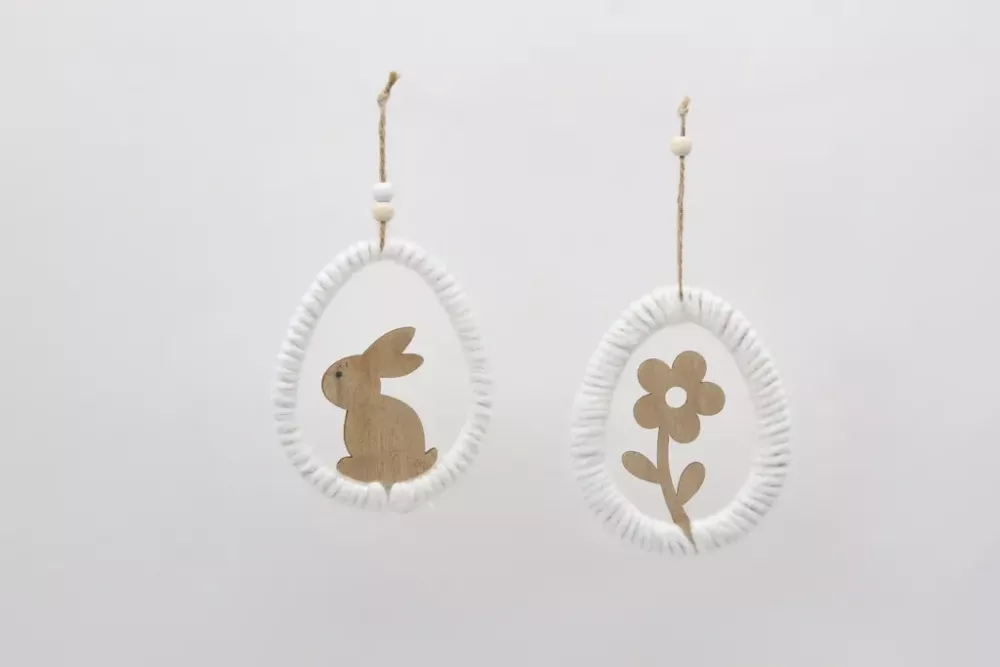 Minimalistischer Osterei-Anhänger aus Holz mit weißem Garn umwickelt und einer Osterhasen-Silhouette in der Mitte