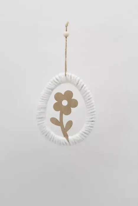 Minimalistischer Osterei-Anhänger aus Holz mit weißem Garn umwickelt und einer Blumen-Silhouette in der Mitte